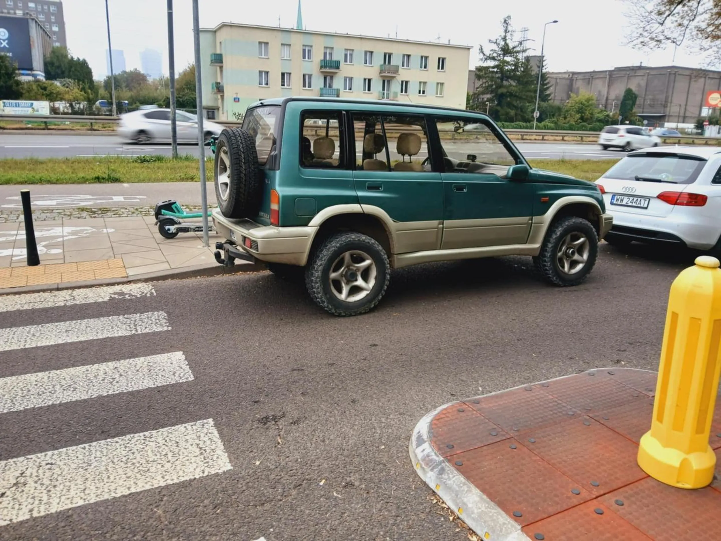 Ten pseudo kierowca parkuje suzuki tuż za przejściem dla pieszych, oraz zmusza innych do omijania po podniesionej wysepce