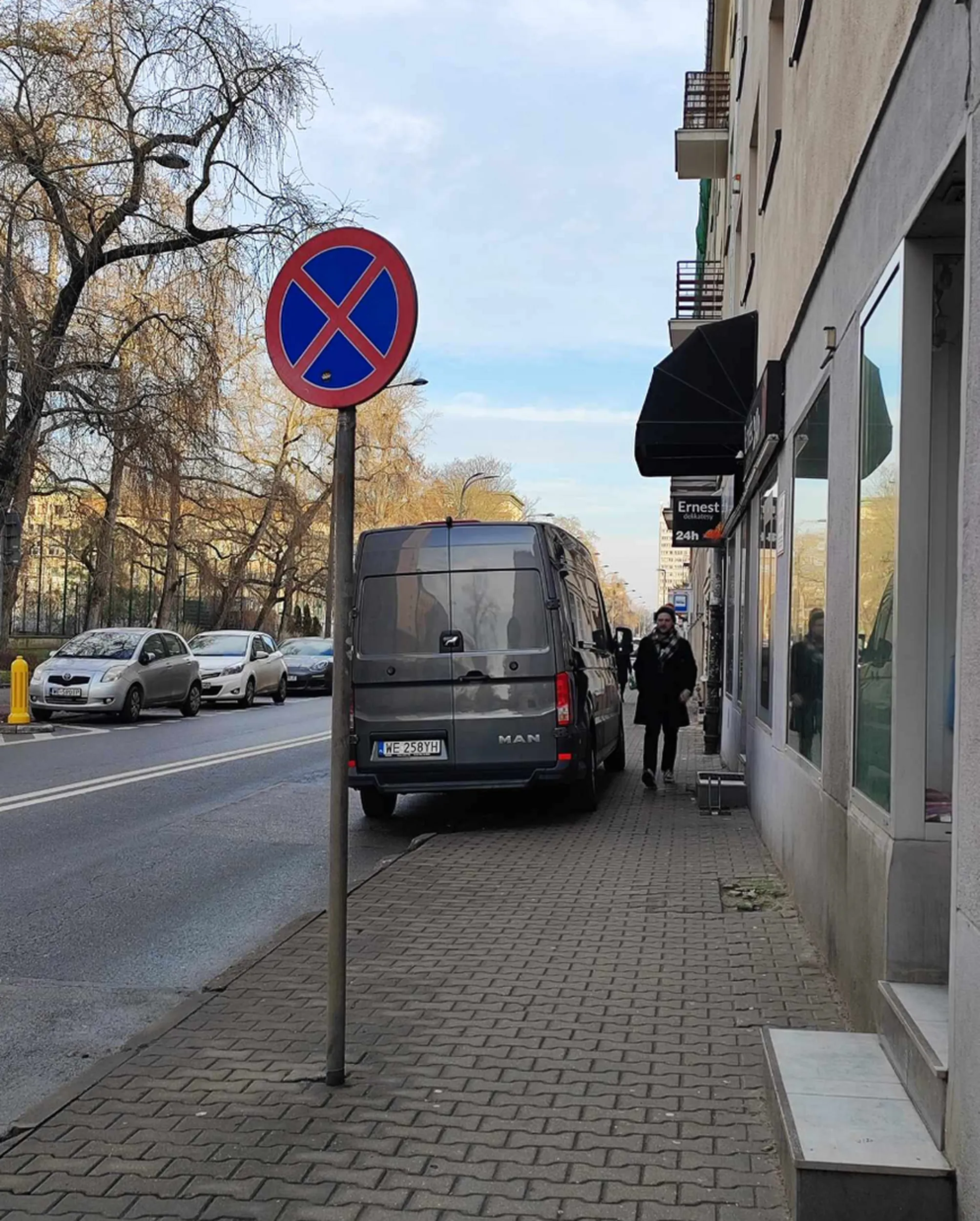 Staje na chodniku tuż przy zakazie postoju, bo ani mu się nie chce zapłacić za parking, ani prawdopodobnie rzeczy na dostawę nosić. Parkuje tuż przy przejściu dla pieszych wielkim busem tak, że zasłania widok i pieszym, jak i kierowcom którzy nie widzą co dzieje się przy przejściu. Zdarza się to notorycznie w tych samych porach jakoś między 13-14 zwykle
