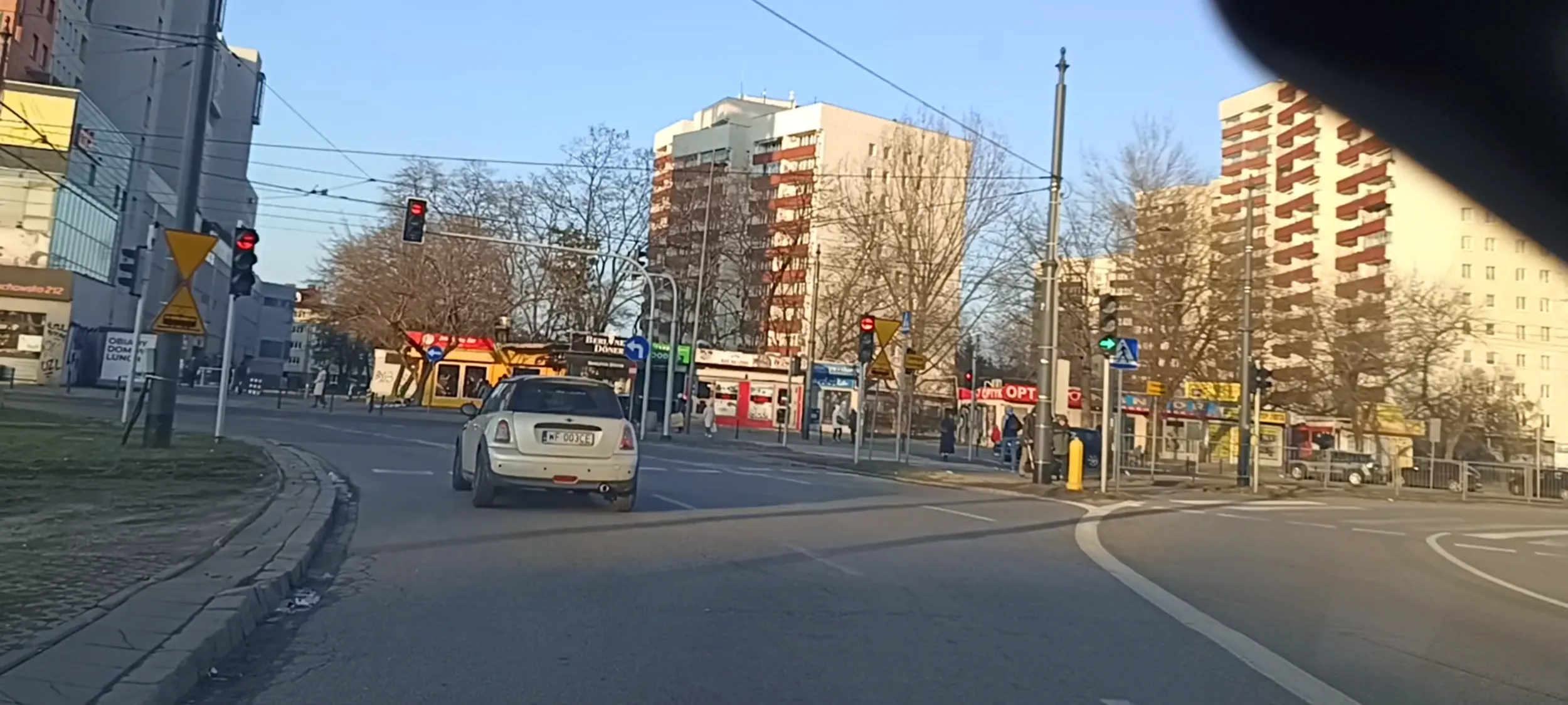 Bandyta drogowy przejeżdża przez skrzyżowanie na czerwonym sygnalizatorze świetlnym