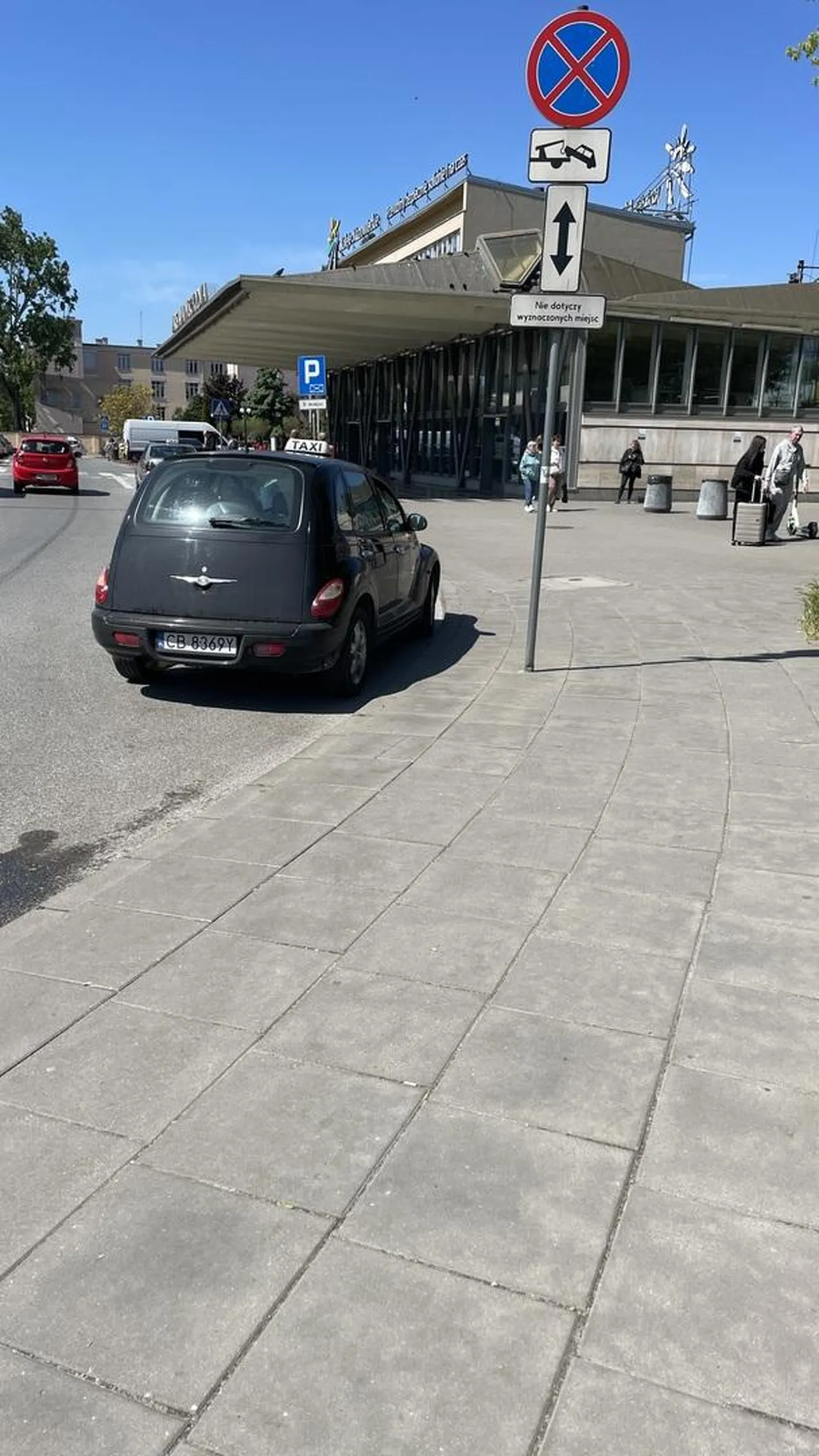 Parkuje na zakazie zatrzymywania razem z kolegami z branży, udając postój taksówek. Brak tabliczki z informacją o cenie przewozu na prawej tylnej szybie.