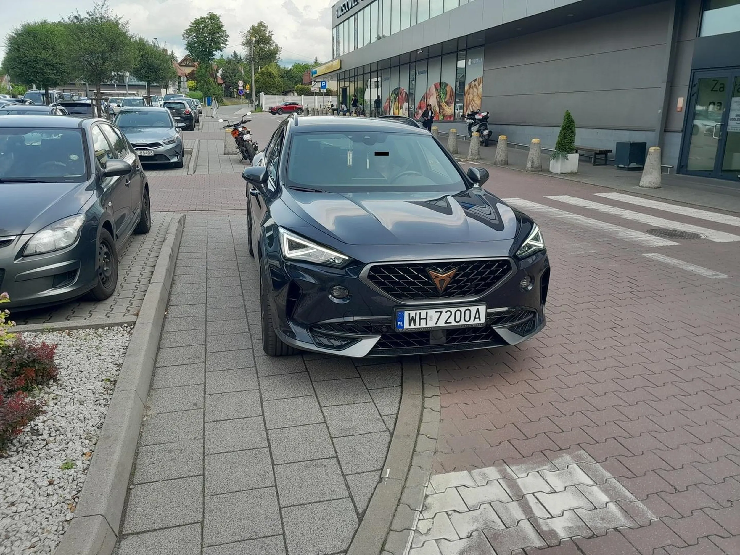 Parkuje na dwóch przejściach dla pieszych jednocześnie, na chodniku nie pozostawiając przejścia dla pieszych. Stoi ponad 10 min z włączonym silnikiem (bo ciepło i klima musi chodzić). Po zwróceniu uwagi, ze strachu blokuje drzwi i wtedy nagle staje się odważny i zaczyna wyzywać i używać wulgarnych słów.