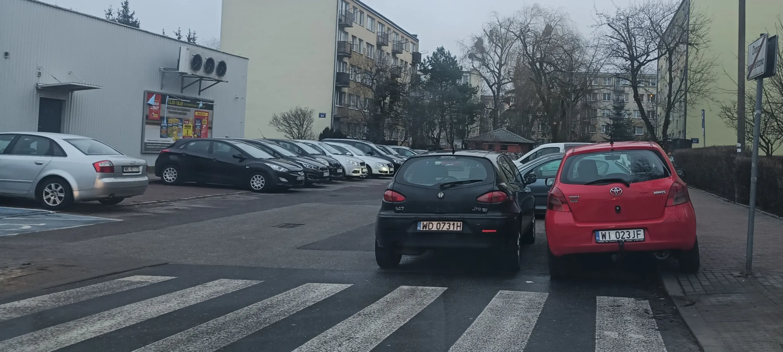 2 przygłupy zaparkowały jak przygłupy przed przejściem i w przejeździe w sposób umożliwiający wjazd śmieciarce do śmietnika.