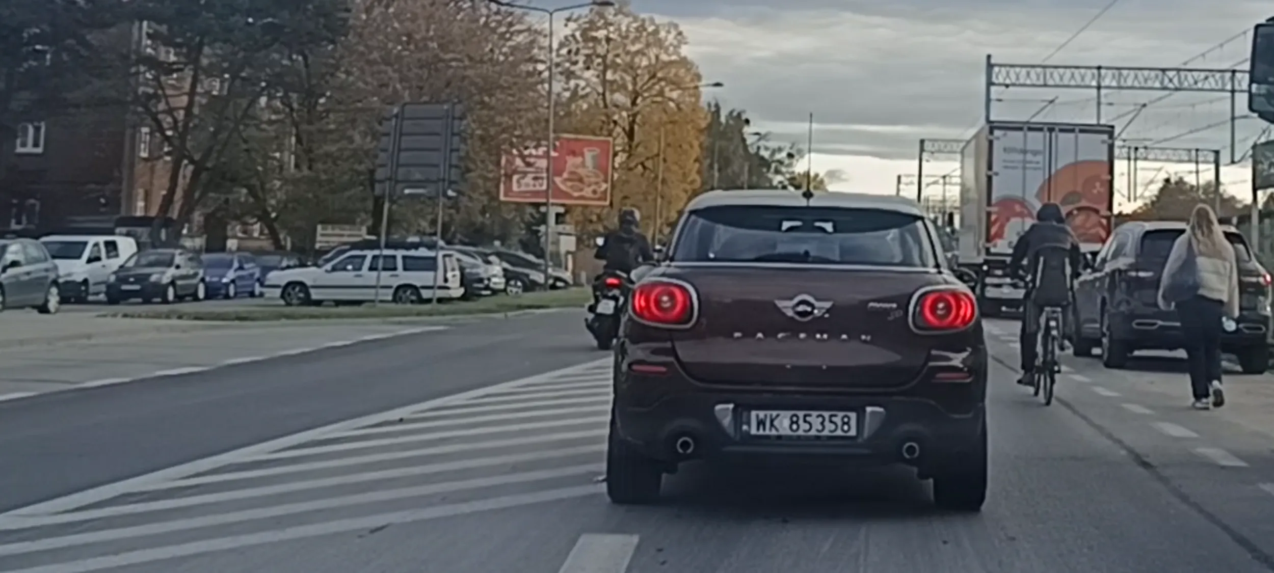 Bandyta drogowy na skuterku nielegalnie wyprzedza na linii ciągłej i po pasie wyłączenie z ruchu.