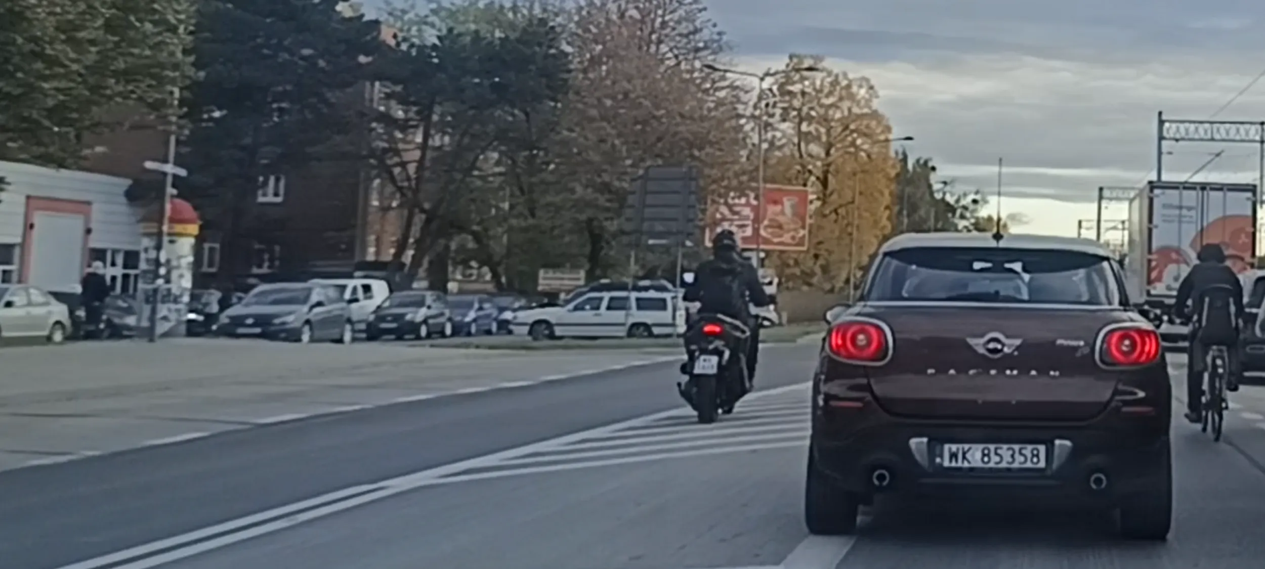 Bandyta drogowy na skuterku nielegalnie wyprzedza na linii ciągłej i po pasie wyłączenie z ruchu.