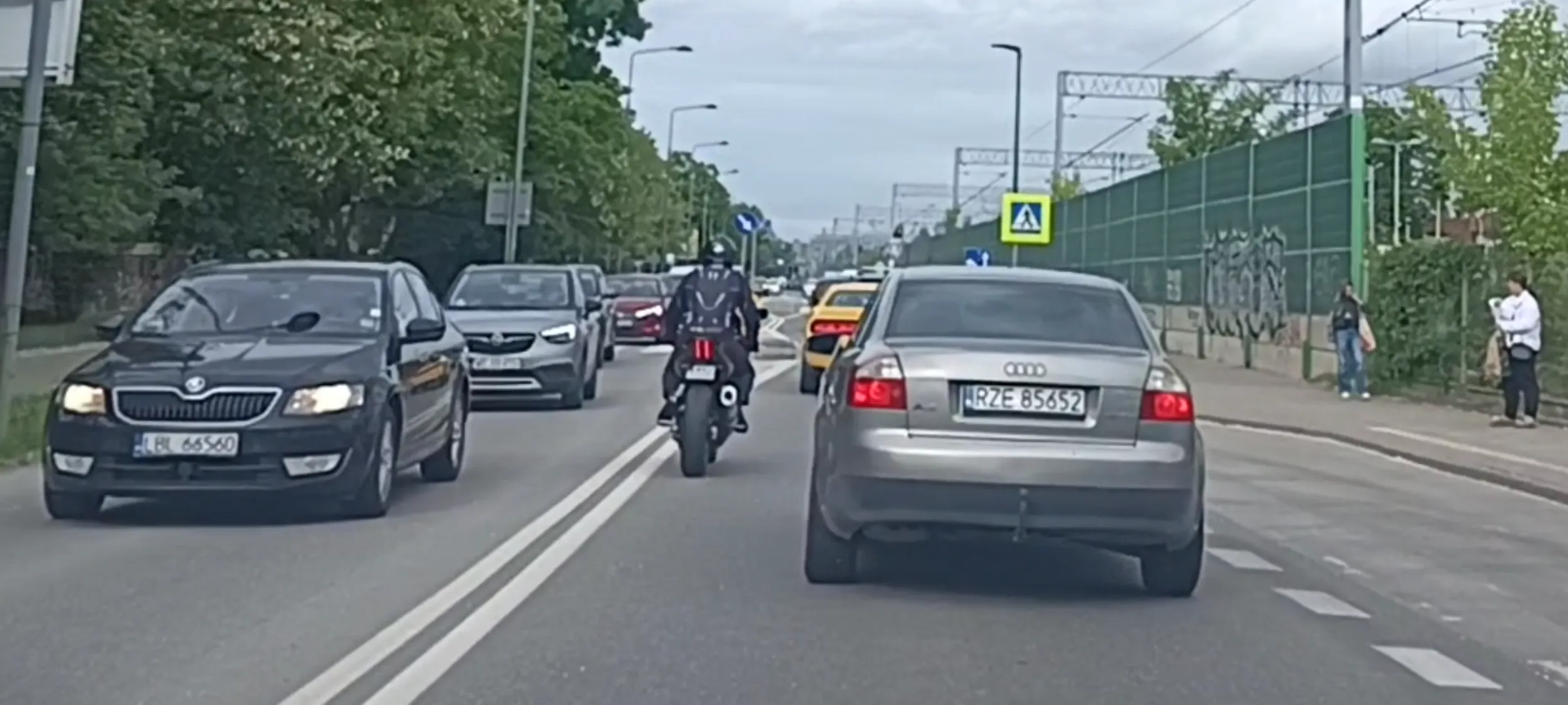 Bandyta drogowy na wraku motorynki wyprzedza po pasie wyłączonym z ruchu a potem wyprzedza przed przejściem dla pieszych przekraczając dopuszczalną prędkość .