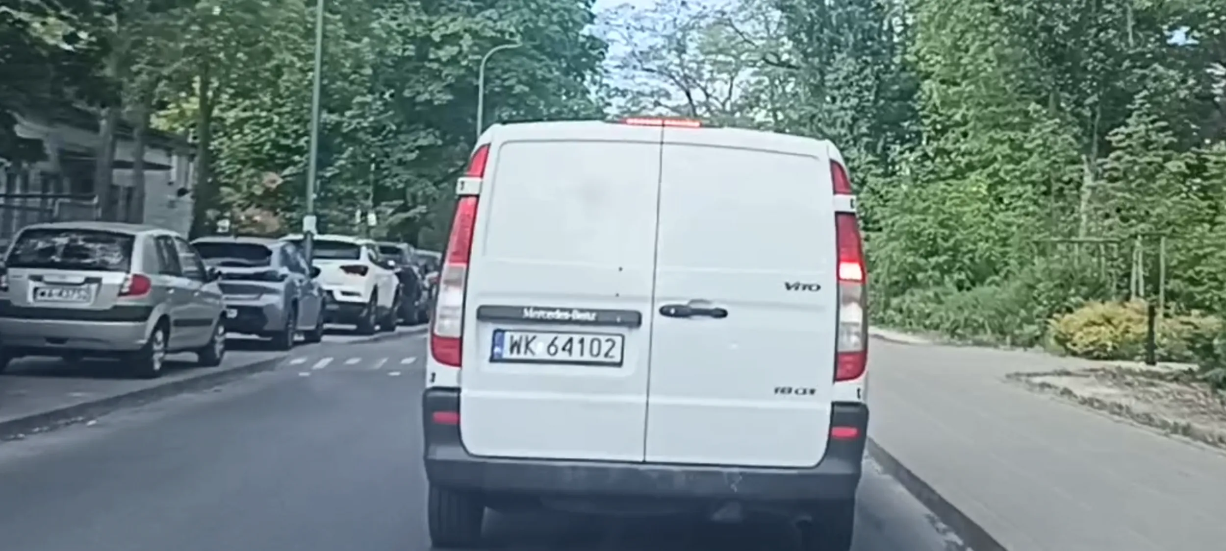 Kierowca ogląda pornosy na telefonie trzymanym w ręku i w czasie jazdy.