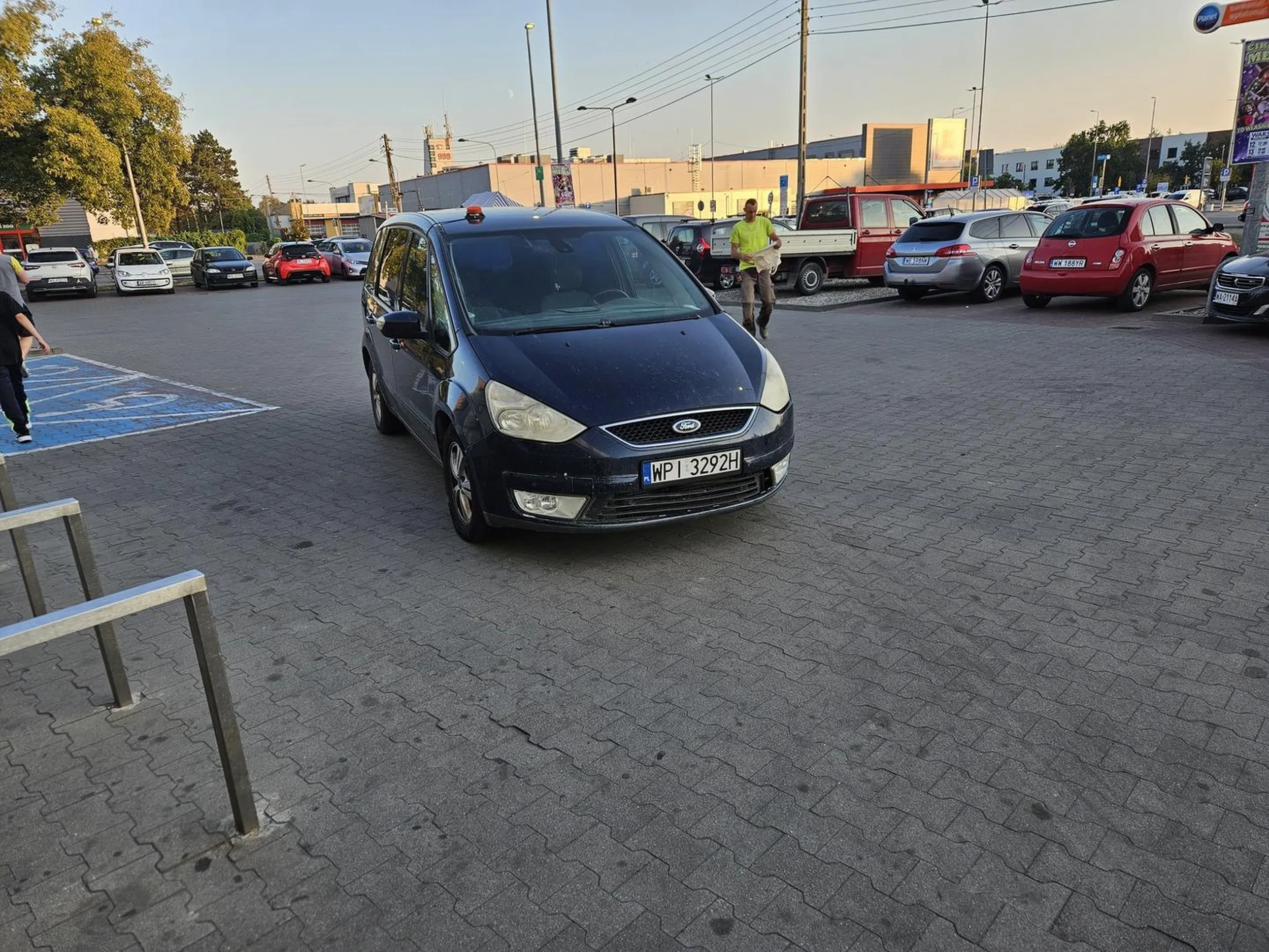 Kierowca zaparkował na środku parkingu przed drzwiami do sklepu.