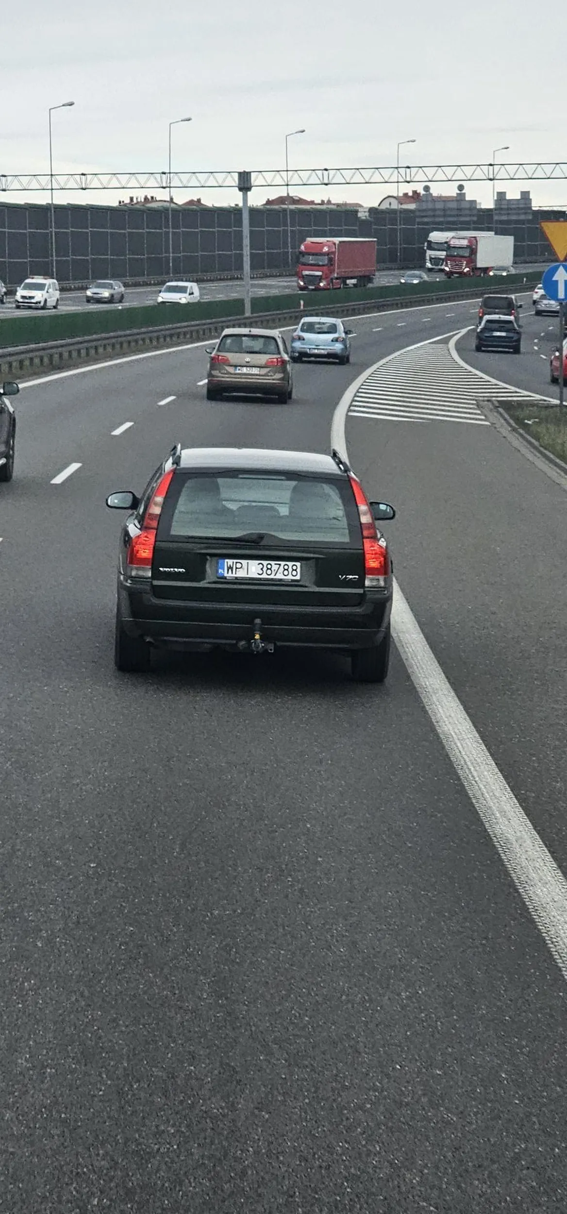 Burak z zielonego volvo, wyhamowuje ciężarówki, macha rękami, zachowuje się jakby był niesprawny umysłowo