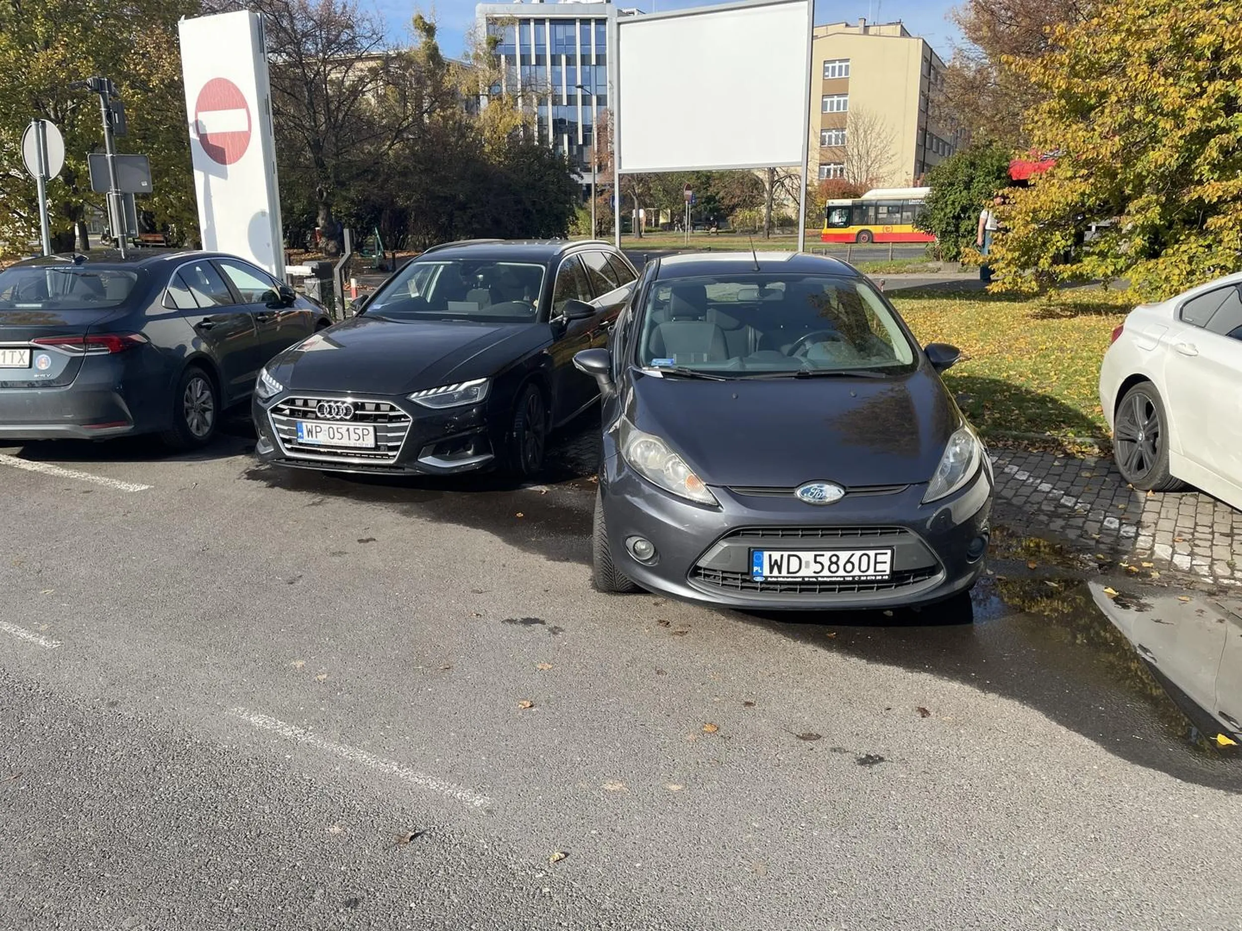 Kierujący środkowym pojazdem złamawszy zakaz skrętu w lewo usiłował zaparkować tyłem pomiędzy widocznym pojazdami. Podczas manewru obtarł pojazd stojący z prawej strony i wielokrotnie uderzył w pojazd po lewej (od strony kierującego