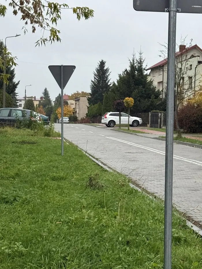 Pojazd zastawiał chodnik (mniej niż 1,5 m, art. 47. 1 prd). Dodatkowo pojazd znajdował się na chodniku mając ponad 2,5 t DMC. Pojazd marki Volvo od miesięcy uporczywie parkuje przed swoja posesją zastawiając wszerz cały chodnik nie zostawiając w ogóle miejsca dla pieszych. Pieszy musi wyjść na ulicę aby go ominąć. Złośliwy właściciel mimo wielu upomnień i mandatów nadal nie stosuje się do przepisów ruchu drogowego. Parkuje przed własną bramą którą codziennie mógłby otwierać i wjeżdżać na posesję. Prosimy o ostateczną interwencję i ukaranie recydywisty.