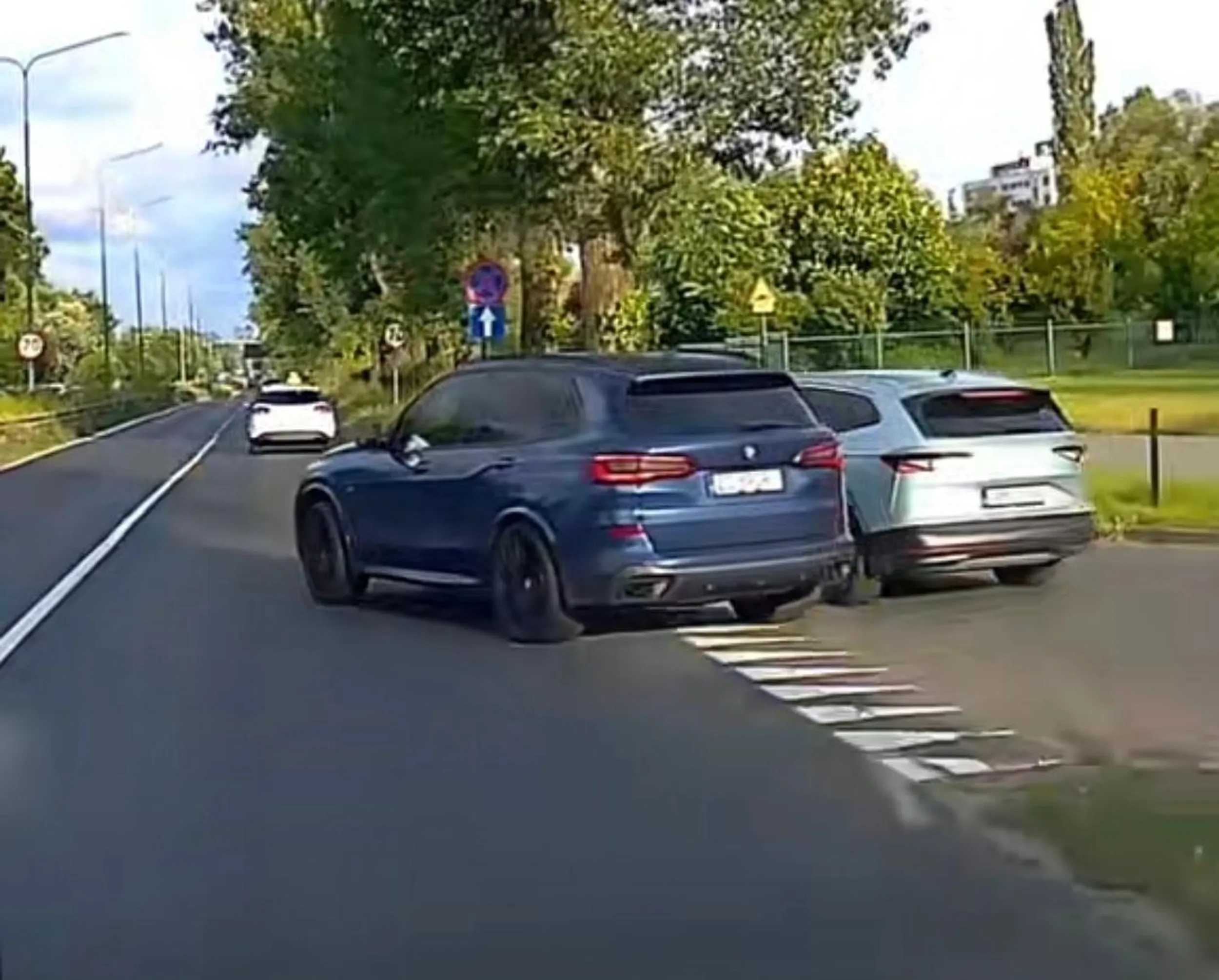 Nieprawidłowe omijanie pojazdu oczekującego na wjazd. Wymuszenie pierwszeństwa. Stworzenie zagrożenia w ruchu drogowym. Niewłaściwe zajmowanie pasa ruchu (brak dwóch wyznaczonych pasów przy wlocie z podporządkowanej). Brak kierunkowskazu sygnalizującego skręt w prawo (typowe dla BMW)