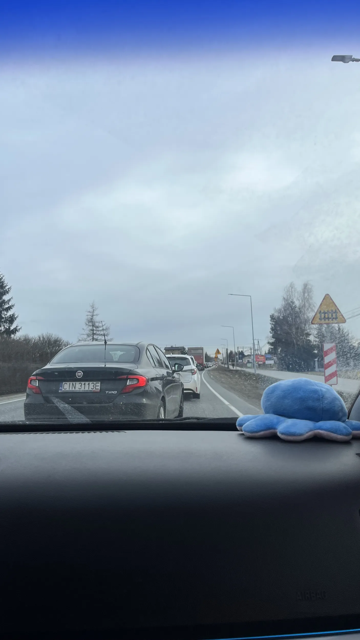 Kierowca jedzie pod prąd bo korek jest za duży przez pociąg który był holowany wbijając się pod maskę i machając rękami żeby stuknąć się w głowę