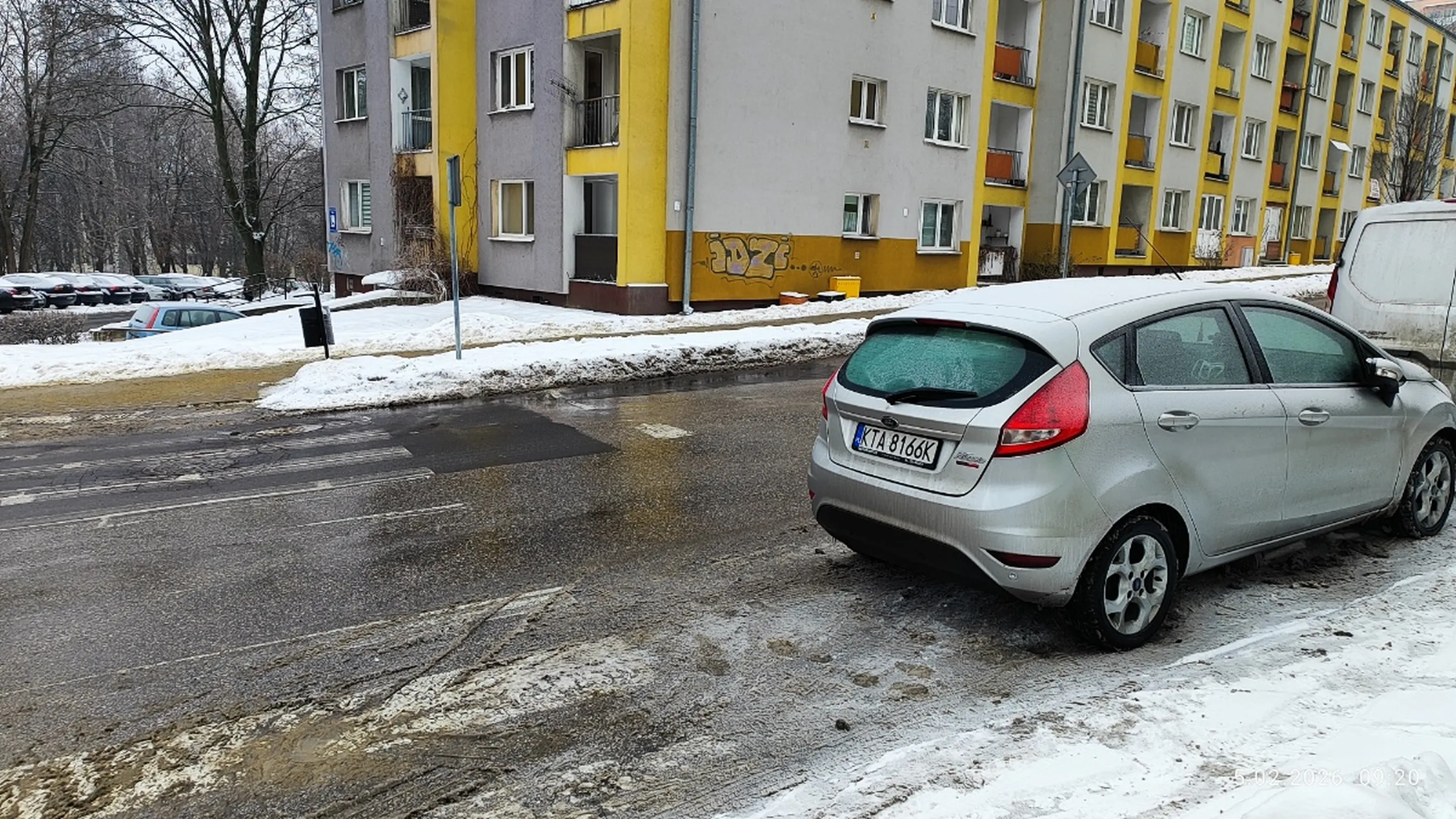 Kierowca parkuje pojazd bezpośrednio za przejściem na drodze dwukierunkowej.