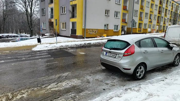 Kierowca parkuje pojazd bezpośrednio za przejściem na drodze dwukierunkowej.