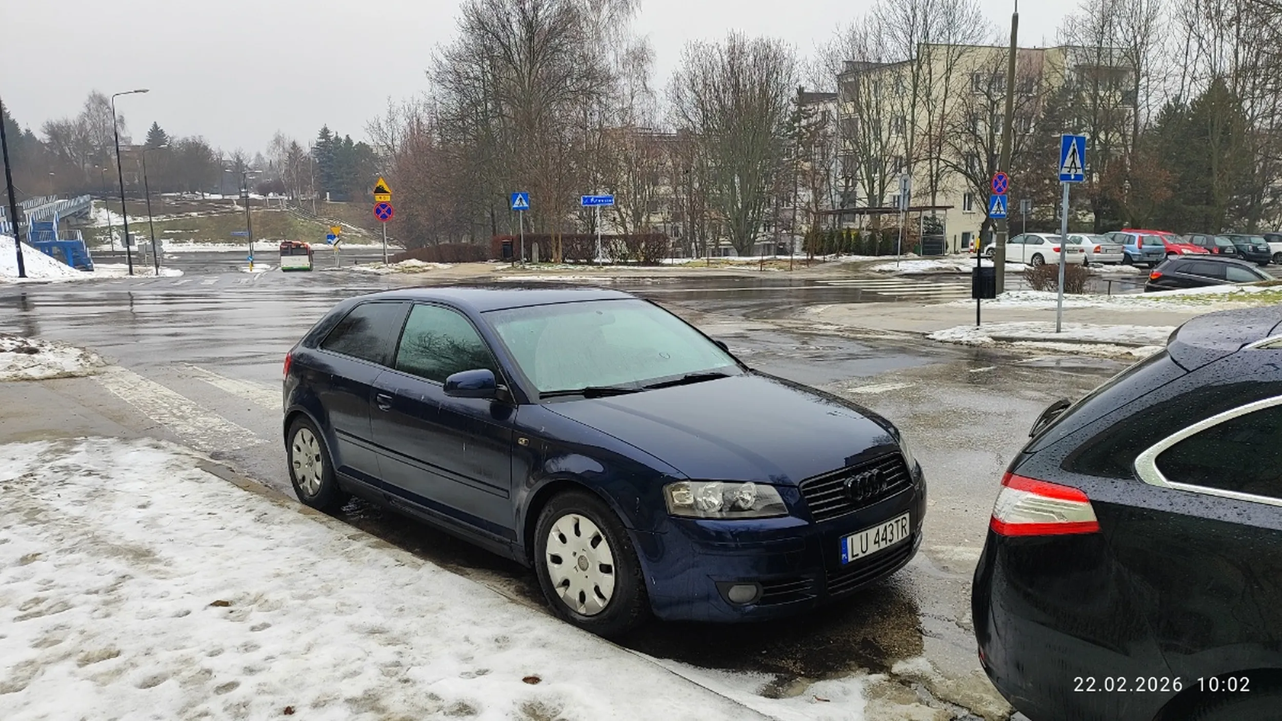 Kierowca parkuje pojazd bezpośrednio za przejściem  dla pieszych na drodze dwukierunkowej.