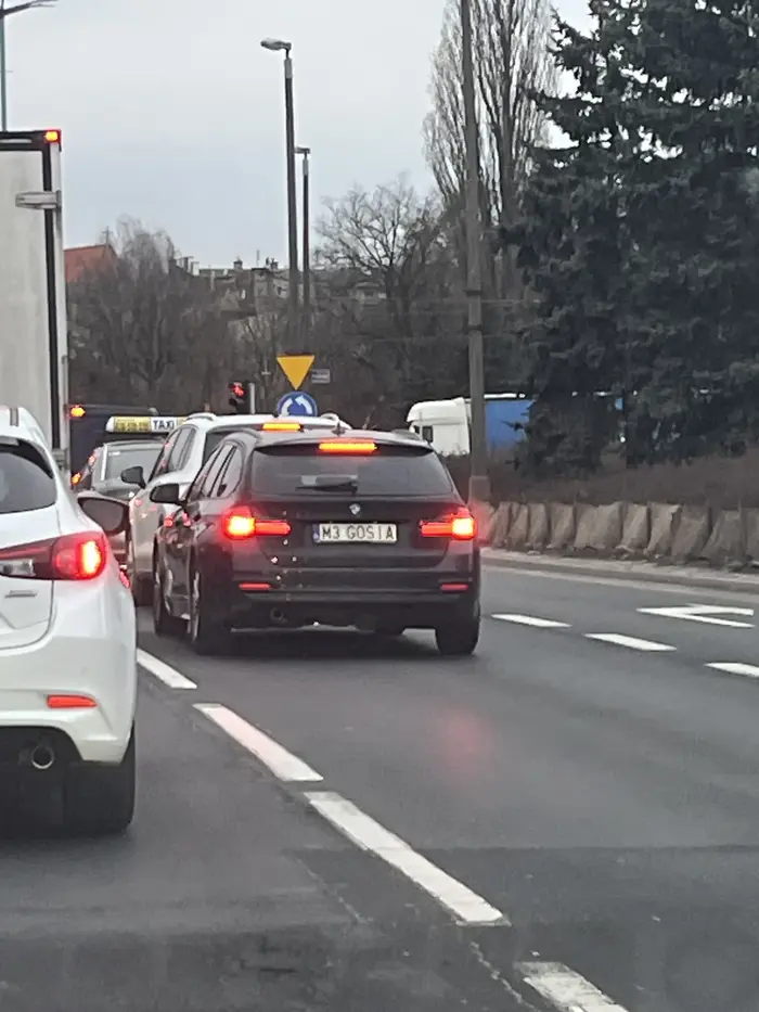 Pani Gosia w swoim małym BMW naprawdę wierzy, że właśnie bierze udział w 24h Le Mans, tylko coś jej się pomyliło i zamiast toru ma zwykłą dwupasmówkę pod miastem. Każde światła to dla niej start honorowy, każde rondo to zakręt życia, a każdy kierowca przed nią to „rywal do zjedzenia”. Największy talent? Dyscyplina olimpijska w przyklejaniu się do cudzego tylnego zderzaka. Gdyby istniały mistrzostwa świata w „jechaniu 30 cm za kimś i wymachiwaniu rękami”, Gosia stałaby na podium, machając kluczykiem jak pucharem.