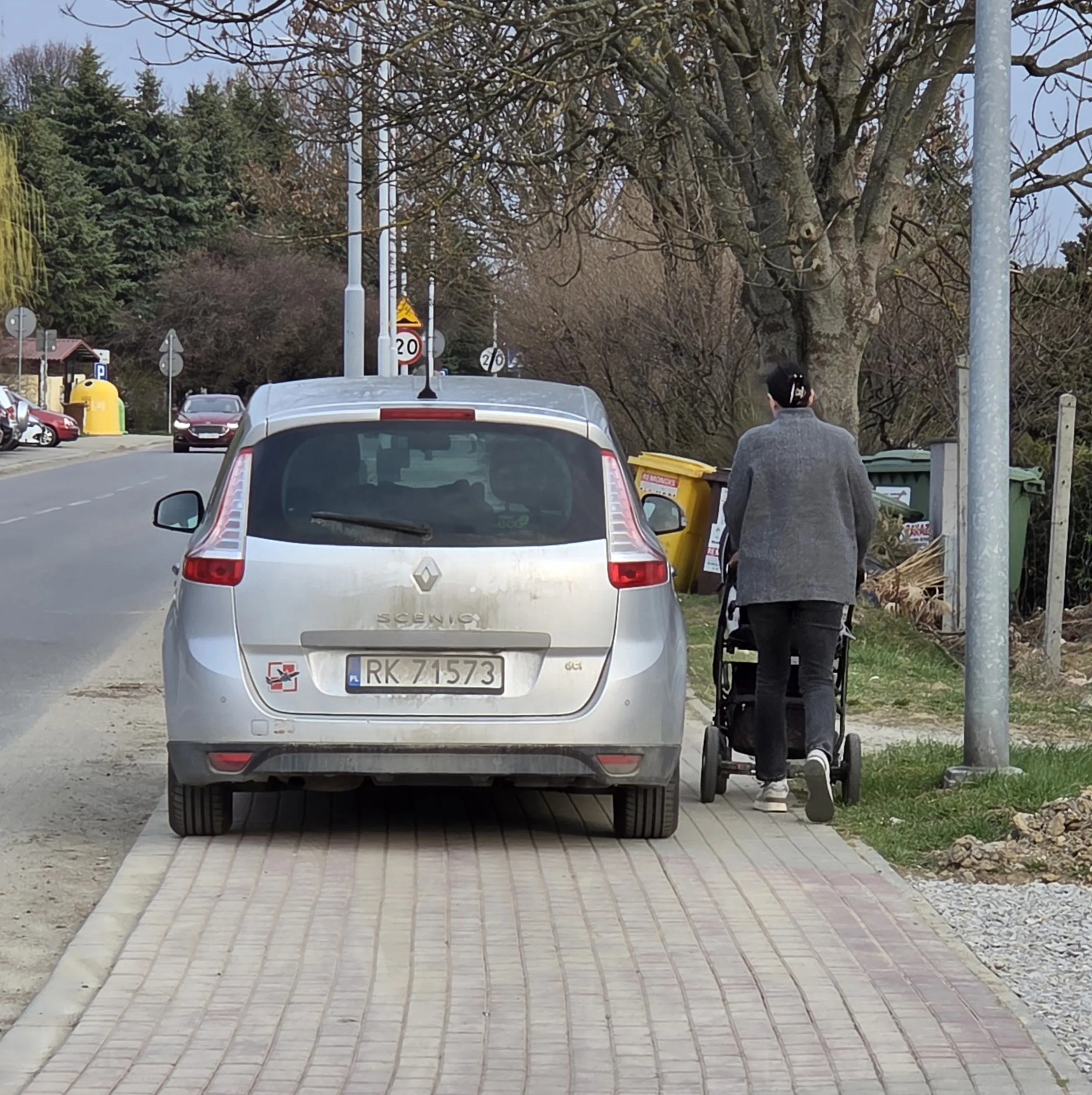Blokowanie chodnika , kobieta z wózkiem musi po trawie chodzić .