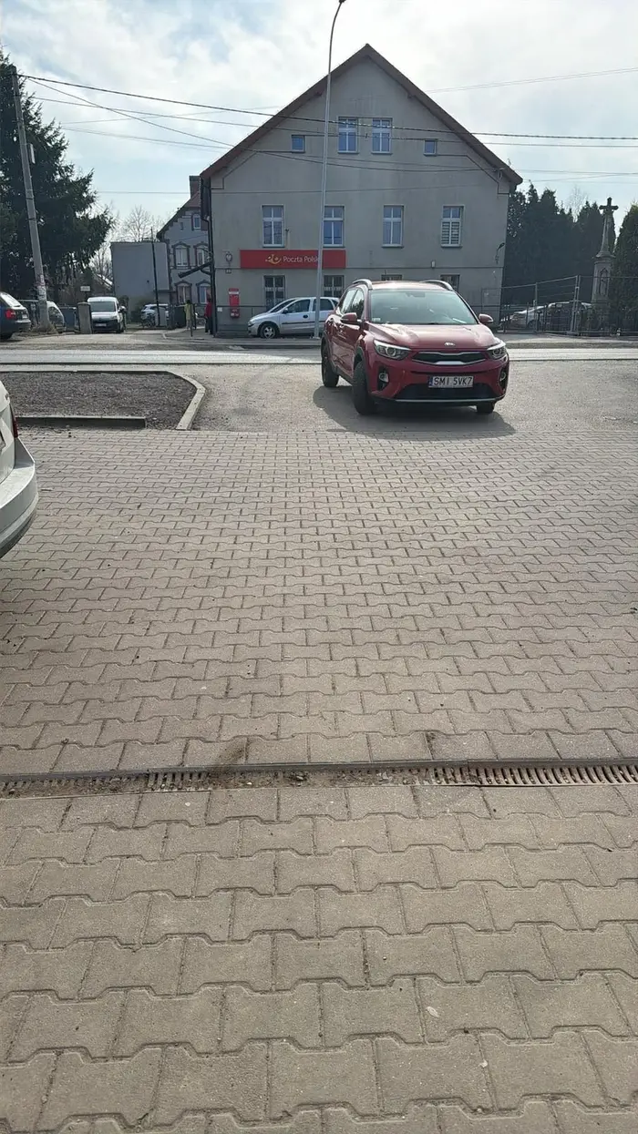 Kierowca parkuje na środku wjazdu mimo zakazu na znaku