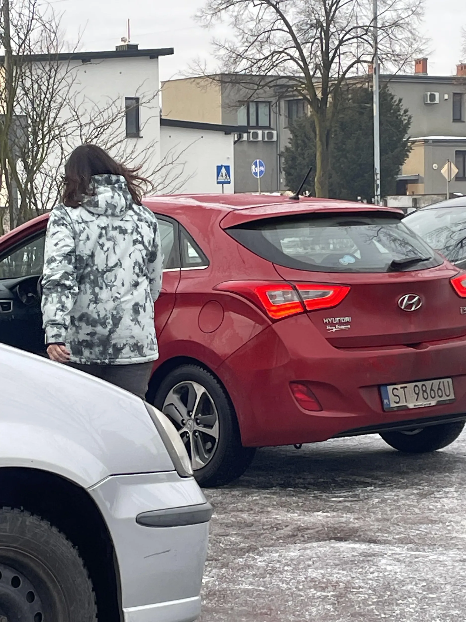Kobieta stanęła na środku parkingu blokując ruch drogowy po czym zaczęła robić zdjęcia przypadkowym samochodowym na parkingu, który jest parkingiem sklepu żabka i każdy może tam parkować.