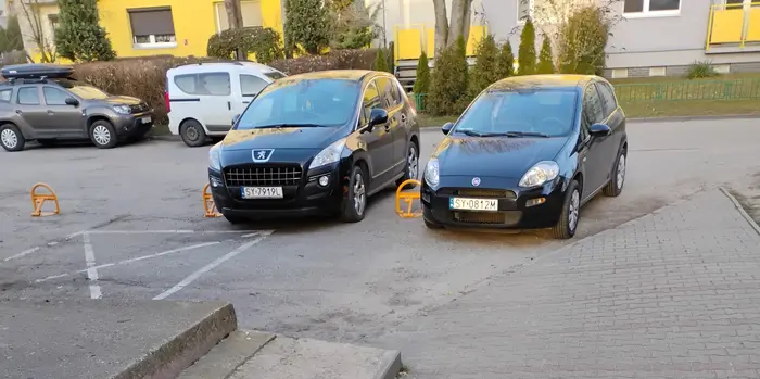 Dwa kretonio wjeżdżają pomiędzy słupki zajmując prywatne miejsca parkingowe