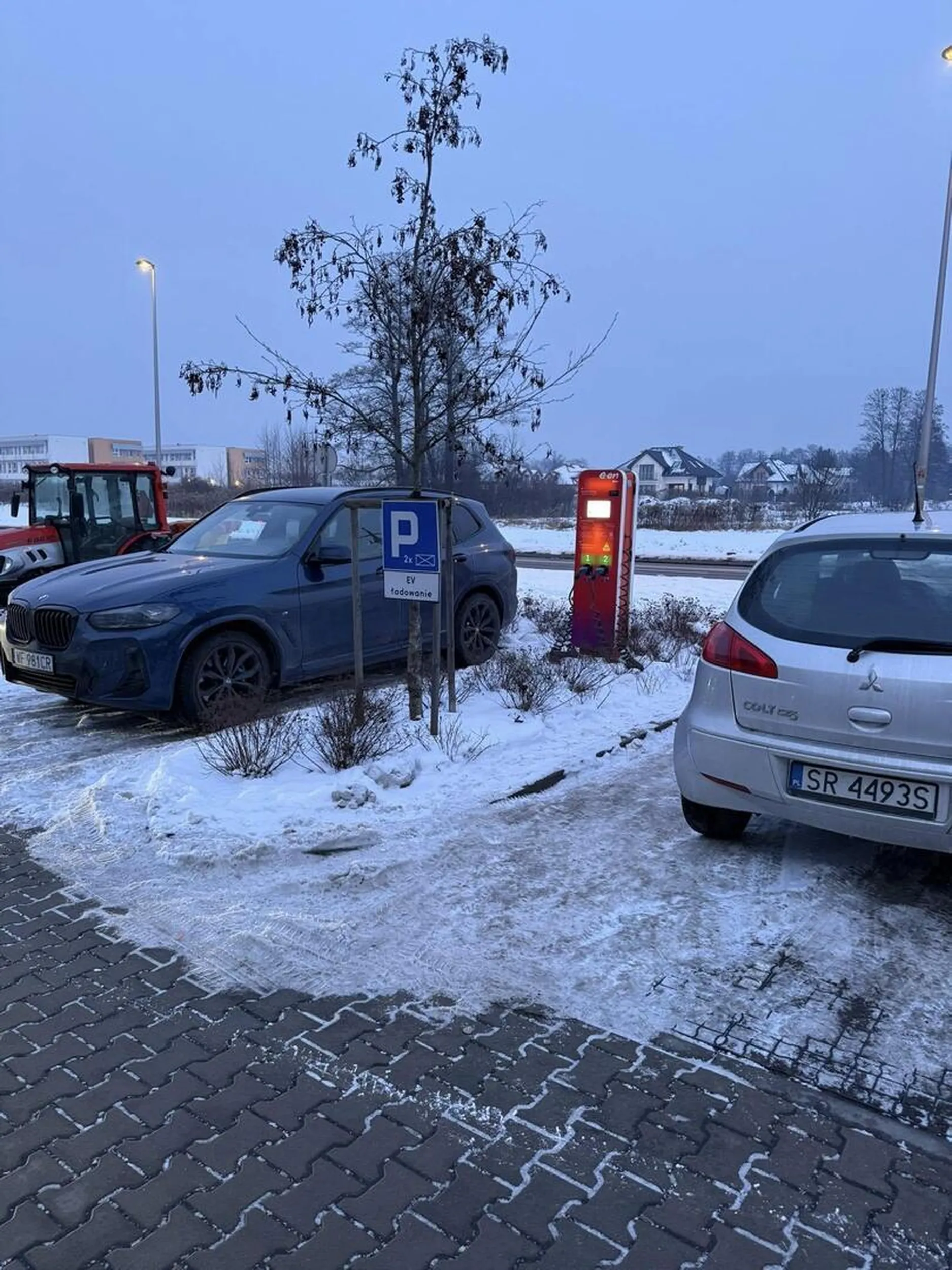 Kurwiarz blokujący miejsce do ładownia EV swoim spalinowozem.