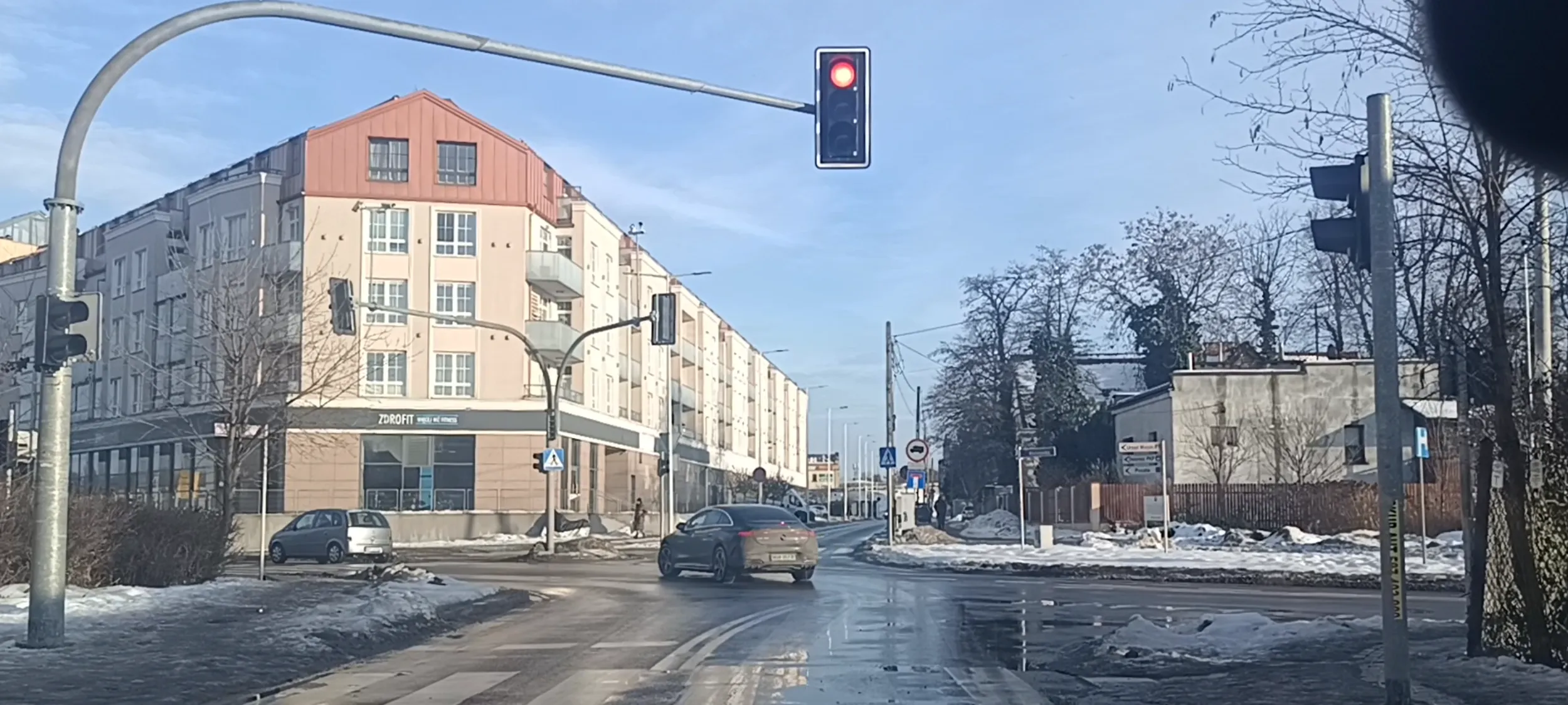 Bandyta drogowy przejeżdża na skrzyżowaniu przy czerwonym sygnalizatorze świetlnym.