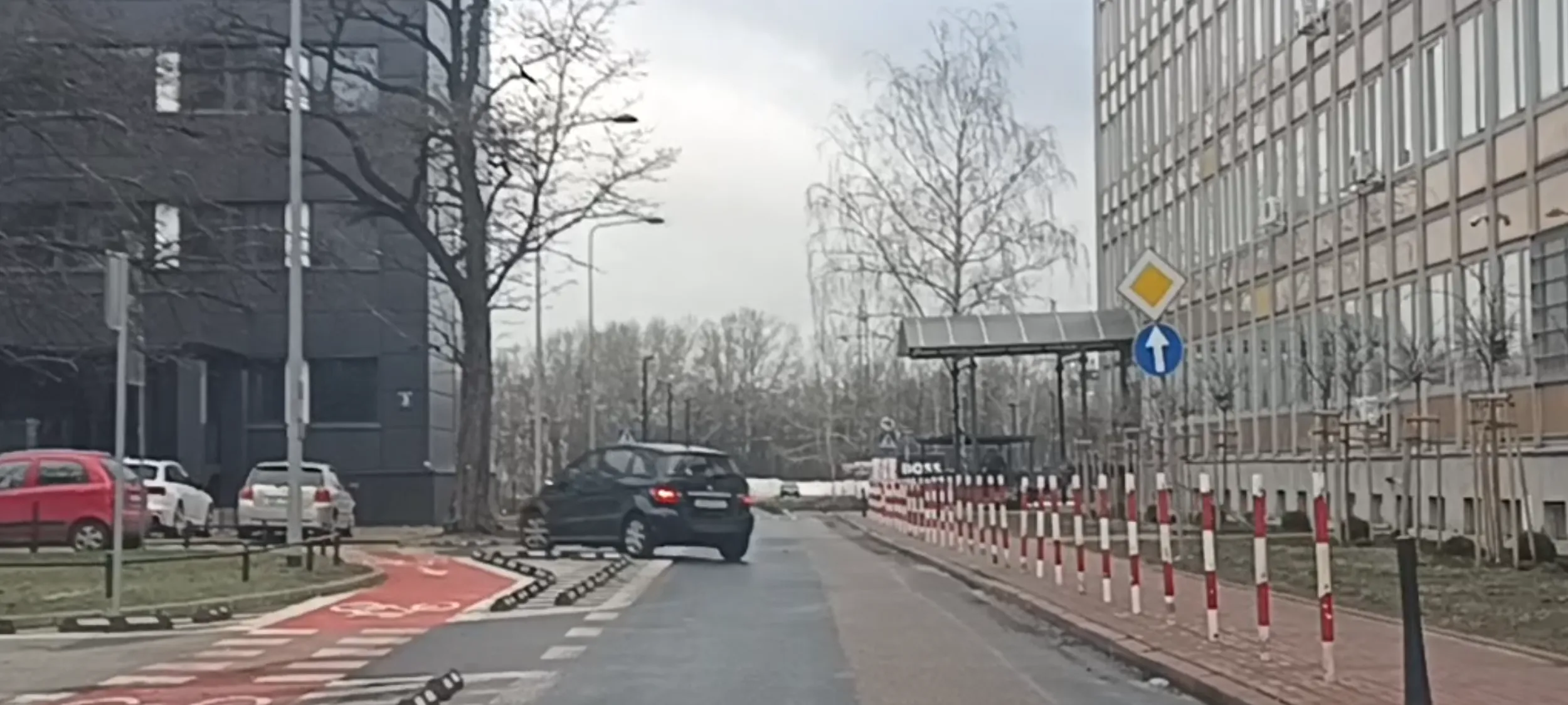 Bandyta drogowy skręca w lewo w ulicę pomimo znaku nakazu jazdy prosto i mógł doprowadzić do wypadku.